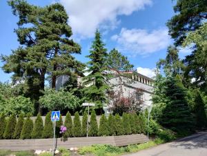 a white house with a fence and a tree at Huone lintukodossa in Helsinki