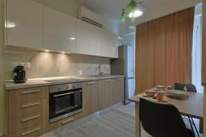 a kitchen with a table and a stove top oven at SIGMA - Signature Living & Easy Parking by Optimum Link in Katerini