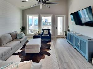 a living room with a couch and a flat screen tv at Serenity At Port A in Port Aransas