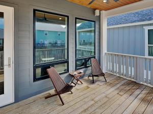 two chairs on a porch with two windows at Serenity At Port A in Port Aransas