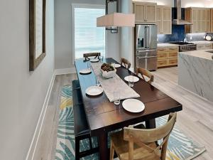 a kitchen with a dining room table with chairs at Serenity At Port A in Port Aransas +23 photos
