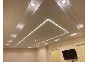 a ceiling with lights and a tv in a room at رويال للغرف الفندقية in Mît Khamîs +1 photo