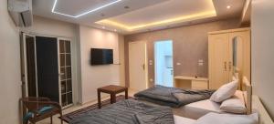 a hotel room with two beds and a television at رويال للغرف الفندقية in Mît Khamîs