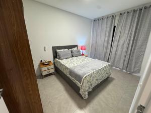 una camera da letto con un letto e un tavolo con una lampada di Casa Nova & Aconchegante a São Bento do Sul