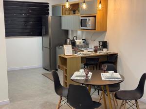 una cucina con tavolo e sedie e una cucina con frigorifero di Casa Nova & Aconchegante a São Bento do Sul