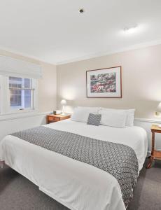 une chambre avec un grand lit blanc et une fenêtre dans l'établissement 109 Water Street Inn, à Boyne City 23 autres photos