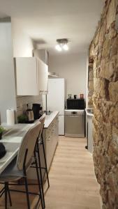 een keuken met witte kasten en een stenen muur bij T2 type new yorkais in Ajaccio
