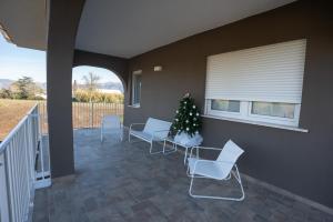een veranda met stoelen en een kerstboom erop bij Casa di Viola - Ortensia in Latina