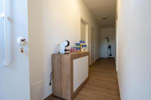 een gang met een witte muur en een tafel met een lamp bij Casa di Viola - Ortensia in Latina