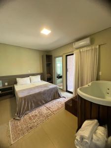 um quarto com uma cama e uma banheira em Recanto Catarina em Cascavel