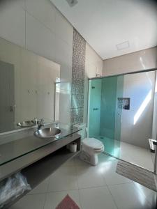 um banheiro com pia, vaso sanitário e chuveiro em Recanto Catarina em Cascavel