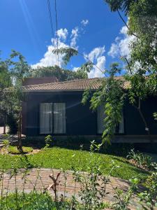 uma casa azul com uma árvore em frente em Recanto Catarina em Cascavel mais 130 fotografias