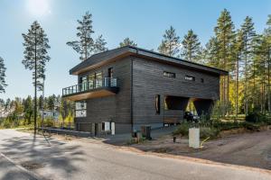 a black house with a balcony on the side of a road at Casa Pickala - The Luxury of life in Hovgård