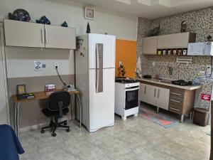 Casa Da Vovó Helena في فيلا فيلها: مطبخ فيه ثلاجة ومكتب