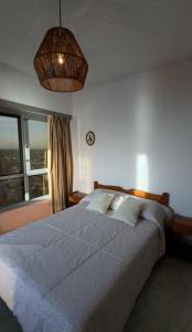 een slaapkamer met een groot bed en een groot raam bij Miramar Vista al Mar in Miramar