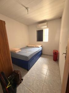 Casa de Praia no Centro de Japaratinga - AL في جاباراتينغا: غرفة صغيرة بسرير ازرق ونافذة