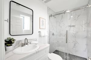 een witte badkamer met een wastafel en een douche bij Fresh & New Downtown LA Condo! in Los Angeles +21 foto's