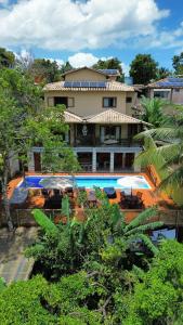 a building with a swimming pool in front of it at Villa Maritaca Condomínio de 4 Casas de Locação por Temporada de Alto Padrão com SPA in Arraial d'Ajuda