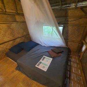 een klein bed in een kamer met een raam bij Khaosok Eco House in Khao Sok +28 foto's