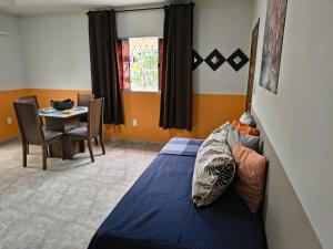 Casa Da Vovó Helena في فيلا فيلها: غرفة نوم بها سرير وطاولة وكراسي