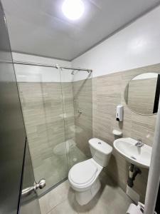 Un baño con inodoro, ducha y lavabo. en GM Suites, en Cúcuta