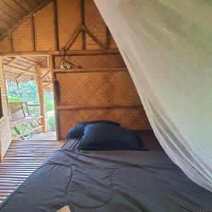 een bed in een tent in een kamer bij Khaosok Eco House in Khao Sok