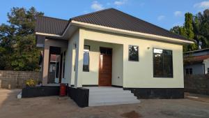 Dans place في موشي: منزل أبيض صغير مع باب بني