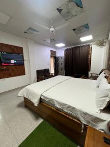 una camera da letto con un letto grande e una TV a schermo piatto di Staylo master Inn a Lucknow Altre 12 foto