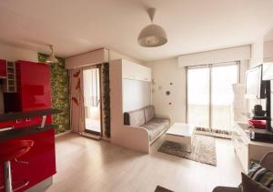 a living room with a couch and red cabinets at Paris à portée de main in Créteil