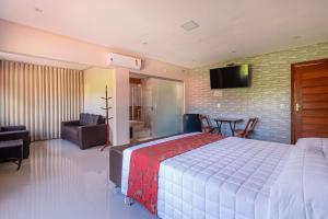 ein Schlafzimmer mit einem großen Bett und ein Wohnzimmer in der Unterkunft Pousada Dona Bili in Pirenópolis