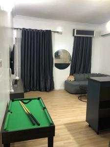 een woonkamer met een pooltafel en een bank bij Sweet Dream Apartment in Lekki