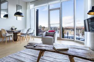een woonkamer met een tafel en grote ramen bij Les Immeubles Charlevoix - Le 760-108 in Québec