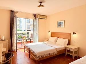 Un dormitorio con una cama y un balcón. en Budva Perla di Mare Hotel, en Budva