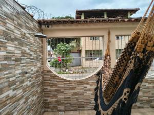 a mirror on the side of a brick wall with two hammocks at Casa Da Vovó Helena in Vila Velha
