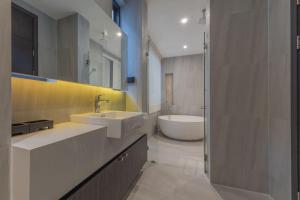 een badkamer met 2 wastafels en een bad bij Maya Luxury Pool Villa Inara in Pattaya South