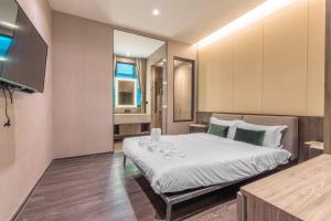 een slaapkamer met een bed en een televisie. bij Maya Luxury Pool Villa Inara in Pattaya South