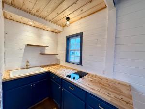a kitchen with blue cabinets and a sink and a window at Eden Village Motel and Cottages in Bar Harbor +252 photos