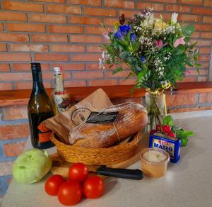 una cesta de pan y una botella de vino y un ramo de flores en Ubytování na Náměstí, en Nové Město pod Smrkem
