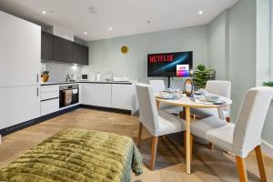 Modern & Cozy Flat in the Heart of Chelmsford - F7 في تشيلمسفورد: مطبخ وغرفة طعام مع طاولة وكراسي