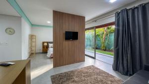 sala de estar con TV en una pared de madera en Pipa de oliveiras, en Pipa