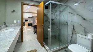 Un baño con ducha de cristal y un inodoro. en Pipa de oliveiras, en Pipa 24 fotos más