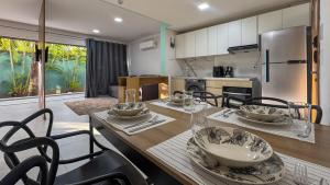 cocina con mesa de madera con sillas y cocina con nevera en Pipa de oliveiras, en Pipa