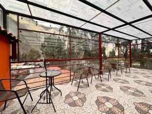 een kamer met stoelen en tafels in een glazen gebouw bij Andher Palace Hotel in Ollantaytambo
