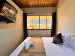 een slaapkamer met een groot bed en een raam bij Andher Palace Hotel in Ollantaytambo
