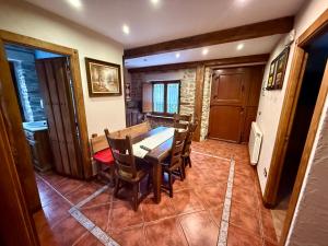 a dining room with a wooden table and chairs at Casa Rural Bango in Caboalles de Abajo