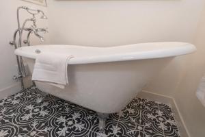 a white bath tub in a bathroom with a tile floor at Old Furnace Inn in Harrisonburg +23 photos