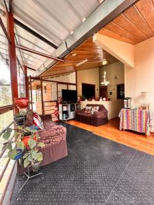 een woonkamer met twee banken en een tv bij Andher Palace Hotel in Ollantaytambo