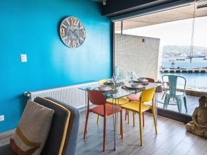 a dining room with a table and chairs and a clock at HOM l Estudio con Vista al mar 3PAX in Valparaíso