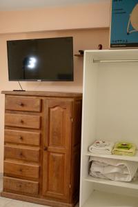 a bedroom with a tv on top of a dresser at Keóken - Frente al Hiper Tehuelche in Caleta Olivia