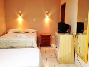a bedroom with a bed and a tv on a dresser at Hotel Comendador Express in Rio Grande